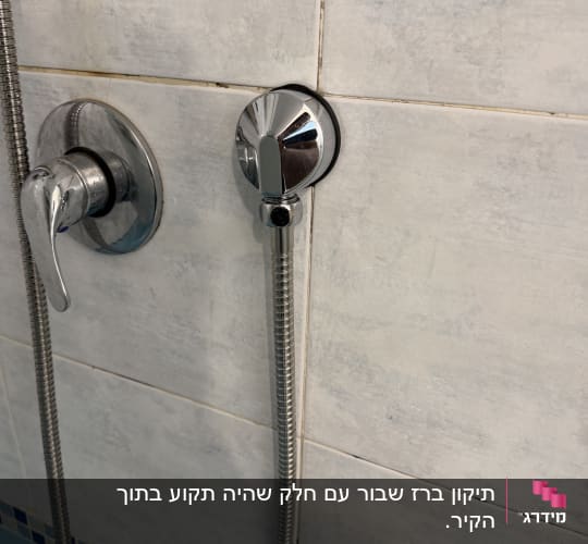 ברז ומקלחת על קיר אריחים בחדר אמבטיה